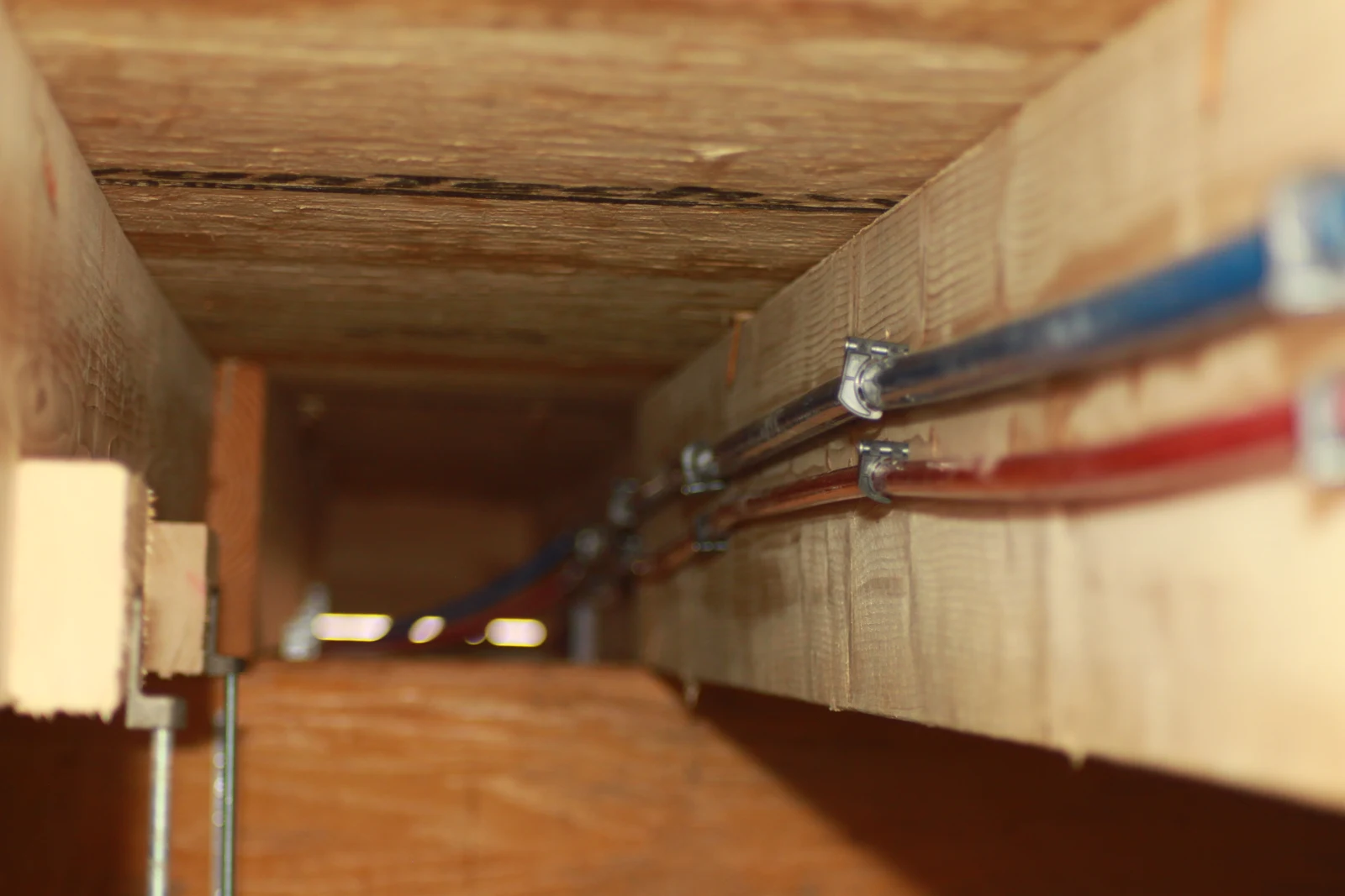 Red and blue water-supply tubing secured along the framing