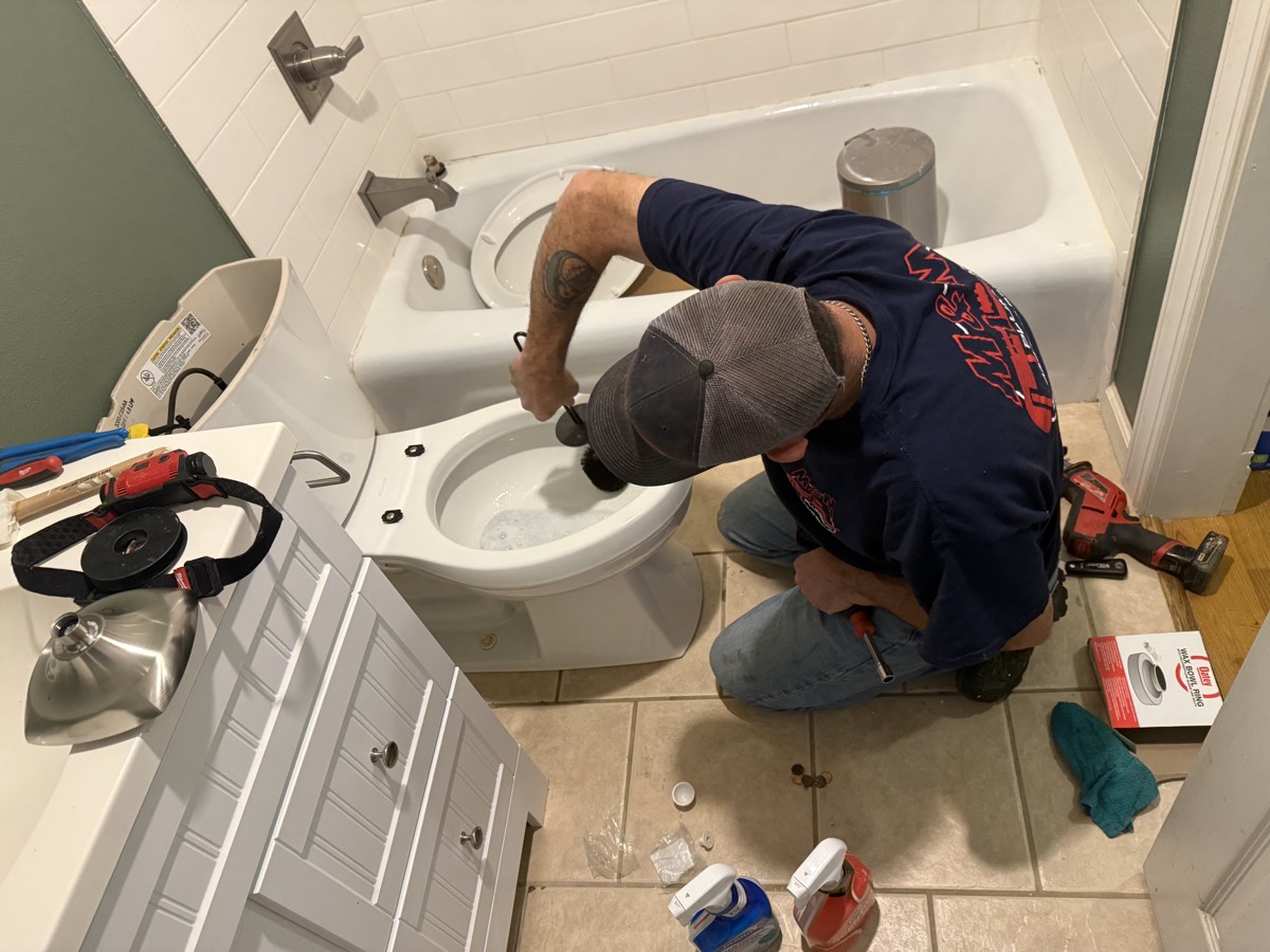 Plumber installing a new toilet during a bathroom update