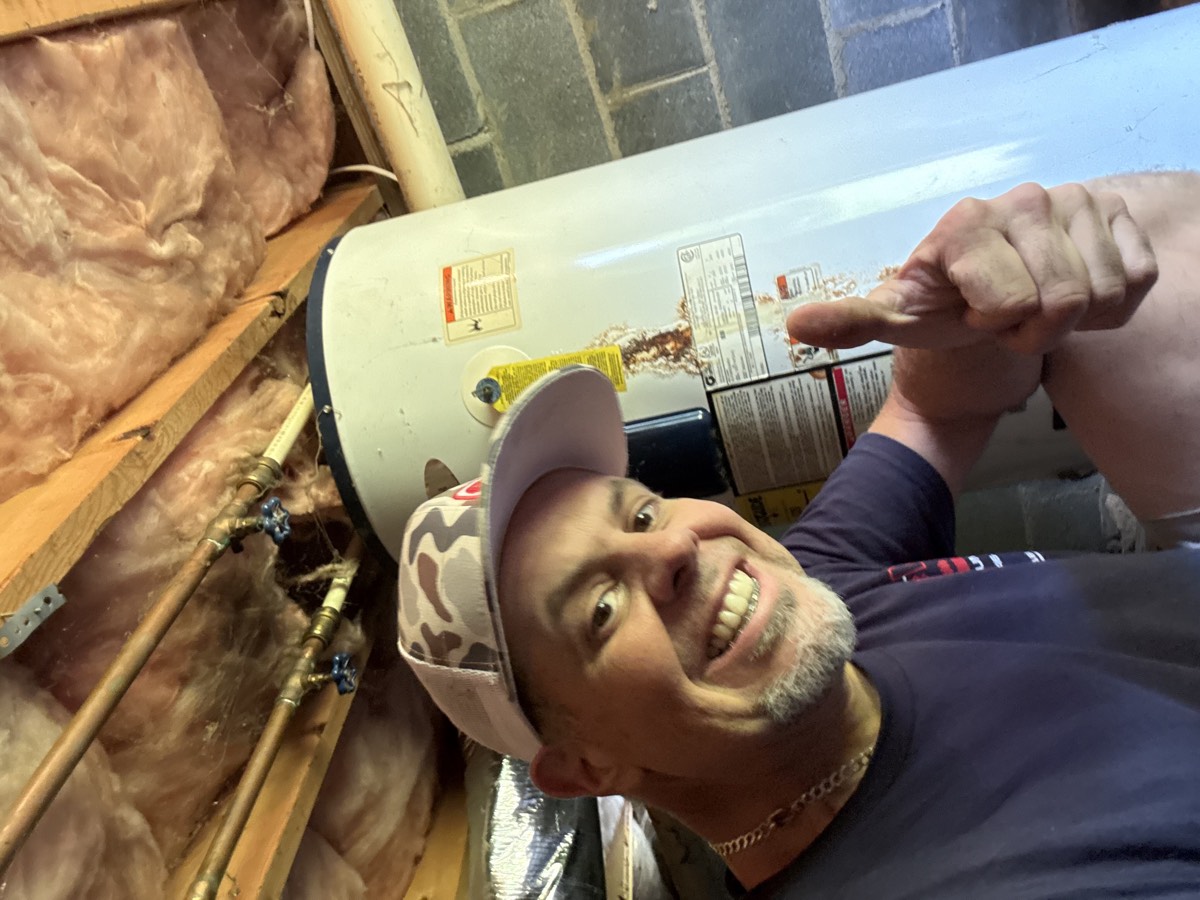 M & M Plumbing owner servicing a residential tank water heater